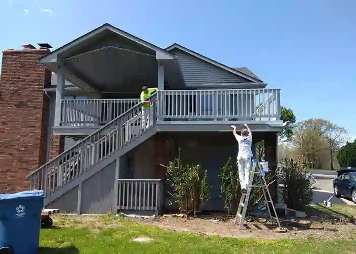 two professional painters staining a deck gray in Joplin, MO